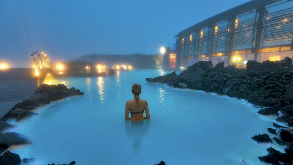 A guest enjoys the warm waters and healing benefits of the ethereal Blue Lagoon at The Retreat in Iceland.